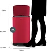 A red kitchen trash can with dimensions indicated, next to a silhouette of a person's legs. Voir les images du produit