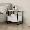 A modern white nightstand with a black frame is placed next to a bed. Podgląd zdjęcia produktu