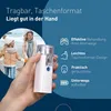 A hand holding a portable nebulizer with a background showing a mother and child on a beach. Náhled obrázku produktu