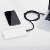A white Wozinsky power bank, a black smartphone, and a laptop are connected by a black cable on a white surface. Náhled obrázku produktu