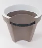 A taupe and white planter with a black ribbed handle. Voir les images du produit