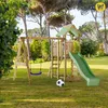 A wooden playground set with a swing, slide, and sandpit is set up on a grassy lawn in a park-like setting with trees in the background. Anteprima dell’immagine prodotto