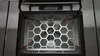 Close-up view of the interior of a pellet stove, showing a hexagonal grate and internal components. Produktbild-Vorschau