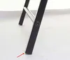 A close-up view of the bottom of a black metal chair leg on a light gray floor. Produktbild-Vorschau
