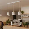 A modern cafe interior with a person sitting at a table and a coffee machine on the counter. Náhľad obrázku produktu