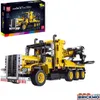 A yellow tow truck model made of building blocks, displayed next to its packaging. Náhľad obrázku produktu