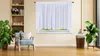 A well-lit room with a chair, plants, and a window with white curtains. Produktbild-Vorschau