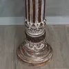 Close-up of the base of a wooden column with decorative carvings. Produktbild-Vorschau