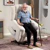 An elderly man is sitting in a beige recliner chair, holding a remote control and a cane. Produktbild-Vorschau
