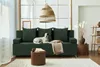 A modern living room with a green sofa, a dog, and a wicker pendant light. Produktbild-Vorschau
