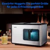 An ice maker is shown on a wooden countertop in a kitchen setting, with a glass of drink to the left. Produktbild-Vorschau