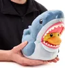 A person is holding a plush toy of a shark with a duck inside its mouth. Podgląd zdjęcia produktu