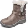 A single taupe winter boot with white faux fur trim and a buckle strap, shown against a white background. Voir les images du produit
