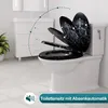 A toilet with a decorative lid is shown in a bathroom setting, with a graphic indicating the lid's movement. Produktbild-Vorschau