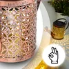 A close-up of a decorative lantern and a watering can shaped solar lamp casting patterned light on a surface, with a hand gesture icon. Anteprima dell’immagine prodotto
