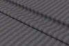 A close-up, diagonal view of anthracite-colored microfiber premium damask striped fabric, folded to show texture and pattern. Produktbild-Vorschau