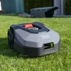 A robotic lawnmower on a green lawn with a charging station in the background. Produktbild-Vorschau
