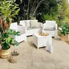 An outdoor patio set with white wicker furniture and plants. Anteprima dell’immagine prodotto