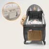 A baby lying in a playpen with a changing station attachment. Produktbild-Vorschau