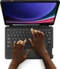 Hands typing on a black keyboard attached to a tablet, showing the screen with a colorful abstract wallpaper. Produktbild-Vorschau