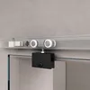 A close-up view of a sliding glass door hardware system mounted on a concrete wall. Voir les images du produit