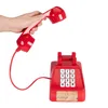A hand holding a red telephone receiver above a red toy telephone with a keypad. Podgląd zdjęcia produktu