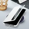 A white smartphone case is placed on a wireless charger, showing the phone's screen with a charging indicator. Podgląd zdjęcia produktu