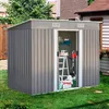 A metal garden shed filled with tools and equipment, situated in a grassy backyard next to a house. Produktbild-Vorschau