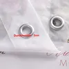 Close-up of two grommets on a white curtain, with a measurement label. Produktbild-Vorschau