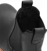 A close-up view of the top opening of a black leather Chelsea boot, showing the fuzzy lining. Voir les images du produit