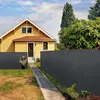 A yellow house with a gray fence in front of it, on a sunny day. Produktbild-Vorschau