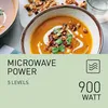 A bowl of soup with toppings and a glass of water in the background, with text overlay describing microwave power. Produktbild-Vorschau