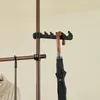A close-up view of a telescopic clothes rack with an umbrella hanging from one of the hooks. Náhľad obrázku produktu
