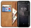 A brown leather flip case for a Sony smartphone, with cards and banknotes inside. Anteprima dell’immagine prodotto