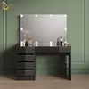 A modern black vanity table with gold accents and a large illuminated mirror, set against a green paneled wall. Produktbild-Vorschau