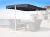 An outdoor patio scene with a table and chairs under a large umbrella. Produktbild-Vorschau