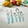 A set of cutlery with blue handles is arranged on a white tablecloth, with fruit in the background. Anteprima dell’immagine prodotto