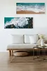 A living room scene with a sofa, coffee table, and artwork on the wall. Produktbild-Vorschau