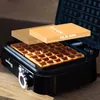 A waffle maker with two waffles inside, and a superimposed graphic showing dimensions. Voir les images du produit