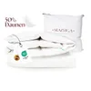 A stack of white bedding products, including a pillow and a folded duvet, with product tags attached. Produktbild-Vorschau