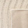Close-up view of a cream-colored rug, showing its texture and the underside. Voir les images du produit