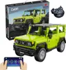 A green Suzuki Jimny toy car model, with its packaging and a remote control, is displayed. Voir les images du produit
