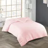 A pink duvet is laid out on a wooden floor in a bedroom setting, with a window and a bedside table visible in the background. Produktbild-Vorschau