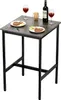 A small square table set for a meal with two plates of food, cutlery, wine glasses, and a bottle of wine. Produktbild-Vorschau