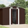 A brown metal shed with white trim is shown outdoors on a paved surface, with greenery and trees in the background. Náhľad obrázku produktu