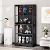 A black, four-tier glass display cabinet filled with various collectible figures and a motorcycle model. The cabinet is placed in a room with a marble pedestal and a decorative artwork in the background. Náhled obrázku produktu