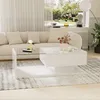 A modern living room with a white couch, a white coffee table with a glass top, and a large window overlooking a garden. Voir les images du produit
