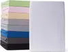 A stack of folded fitted sheets in various colors next to a white fitted sheet. Náhľad obrázku produktu