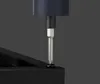 A close-up shot of a precision screwdriver with a blue handle and a silver bit, being used to screw a black screw into a black surface. Voir les images du produit