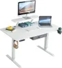 A white adjustable standing desk with a monitor, laptop, keyboard, mouse, headphones, and a cup holder. Anteprima dell’immagine prodotto